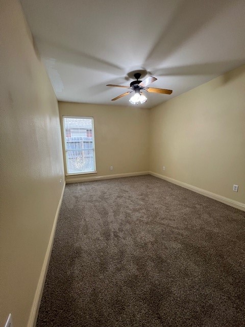 carpeted empty room featuring ceiling fan