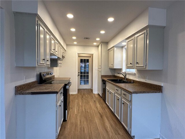 6118 Locke, Corpus Christi, TX 78415 - kitchen featuring stainless steel appliances, dark countertops, under cabinet range hood, dark wood-style flooring, and recessed lighting