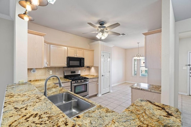 kitchen with visible vents, a sink, decorative backsplash, black microwave, and gas range