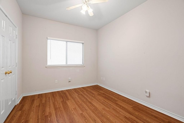 interior space with ceiling fan, a closet, baseboards, and wood finished floors