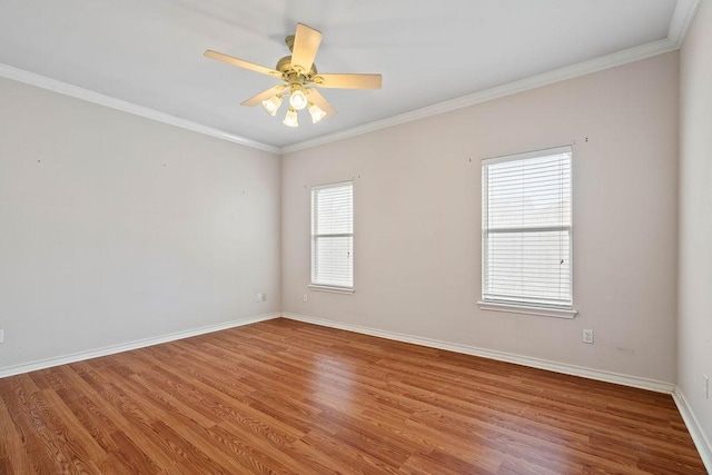 unfurnished room with a ceiling fan, crown molding, baseboards, and wood finished floors