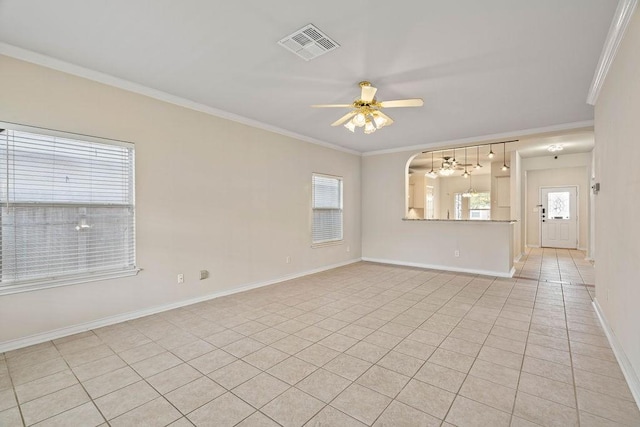 empty room featuring light tile patterned floors, a ceiling fan, baseboards, visible vents, and ornamental molding