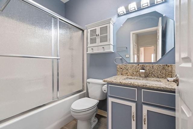 bathroom with vanity, toilet, and shower / bath combination with glass door