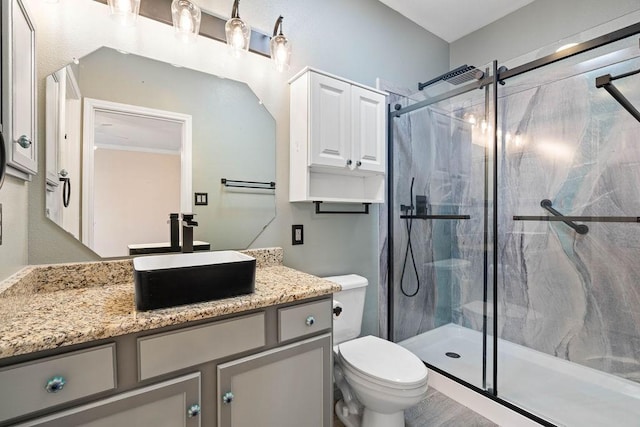 bathroom with vanity, toilet, and a marble finish shower