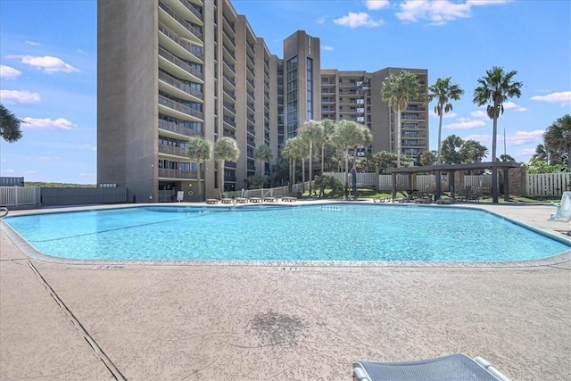 community pool featuring fence and a patio area