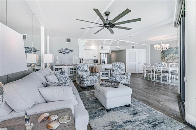 living area featuring visible vents, ceiling fan with notable chandelier, and dark wood-type flooring