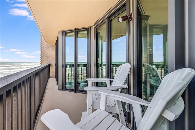 balcony with a water view and a beach view