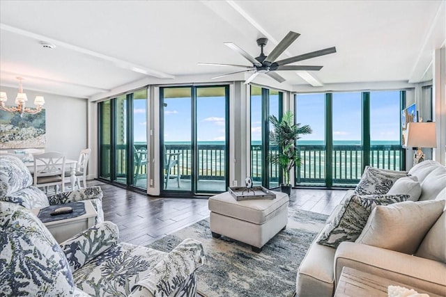living area featuring a water view, plenty of natural light, expansive windows, and hardwood / wood-style flooring