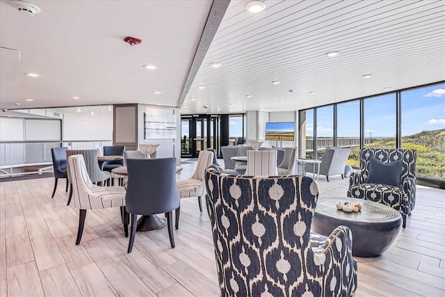 dining space with recessed lighting, expansive windows, and light wood-style flooring
