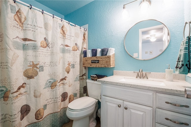 bathroom featuring toilet, vanity, a shower with shower curtain, and a textured ceiling