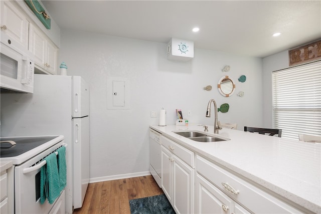 kitchen featuring white cabinetry, hardwood / wood-style floors, sink, and white appliances