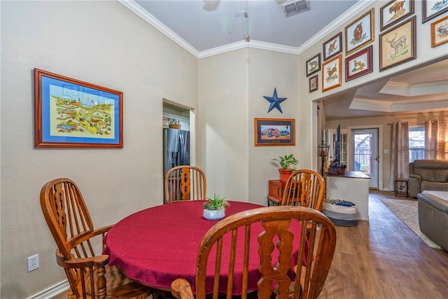 dining space with ornamental molding and wood-type flooring