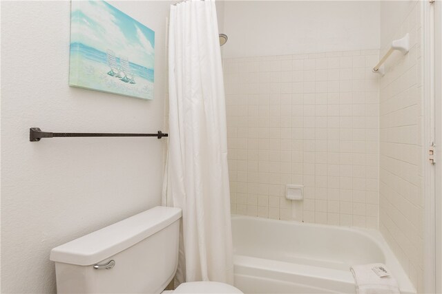 bathroom with shower / bath combo and toilet