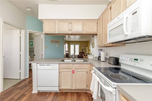 kitchen with white appliances, dark hardwood / wood-style floors, sink, and kitchen peninsula