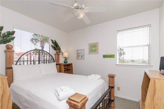 bedroom featuring ceiling fan, a textured ceiling, and carpet flooring