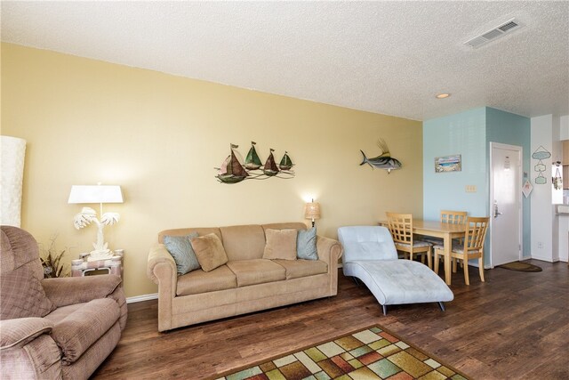 living room featuring a textured ceiling and dark hardwood / wood-style floors