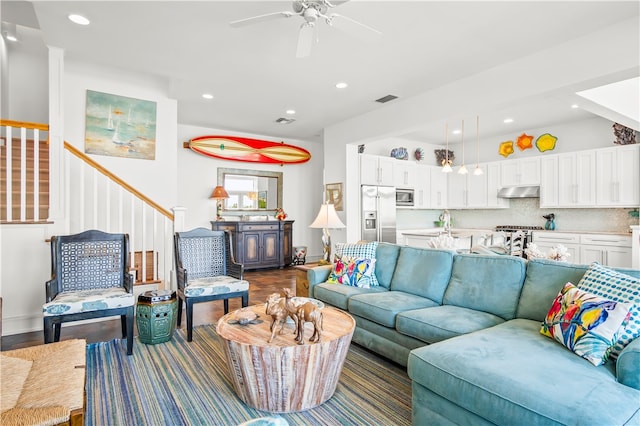 living room featuring dark wood-type flooring, ceiling fan, and sink