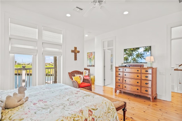 bedroom featuring access to outside, a water view, wood-type flooring, and ceiling fan