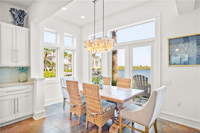 dining space with a chandelier and a water view