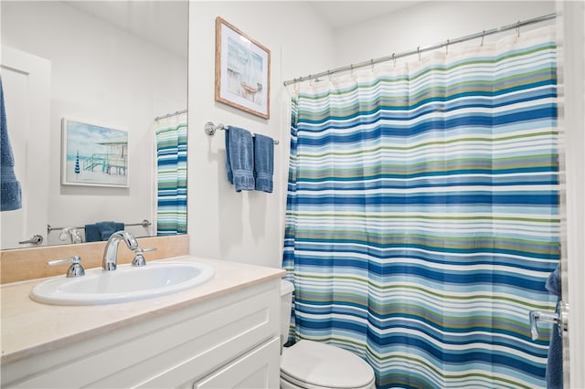 bathroom with curtained shower, vanity, and toilet