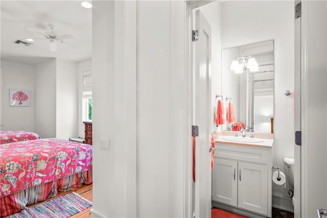 bedroom featuring hardwood / wood-style flooring, ceiling fan, and sink