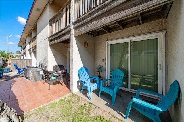 view of patio with a balcony and central AC unit