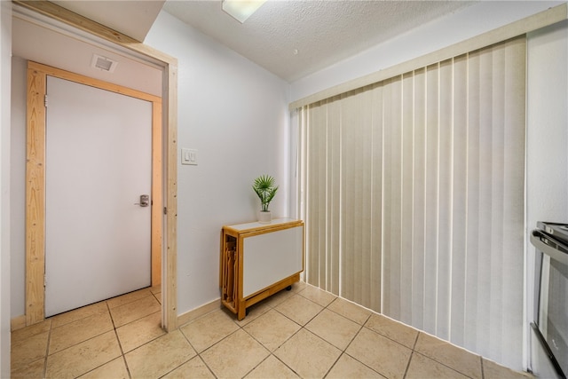 interior space featuring light tile patterned floors and a textured ceiling