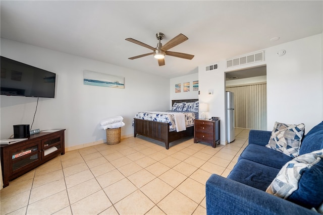 bedroom featuring light tile patterned floors, stainless steel refrigerator, and ceiling fan