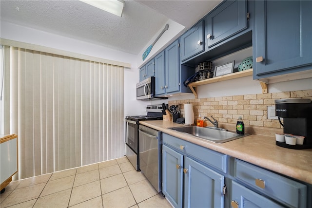 kitchen with backsplash, sink, blue cabinetry, appliances with stainless steel finishes, and light tile patterned flooring