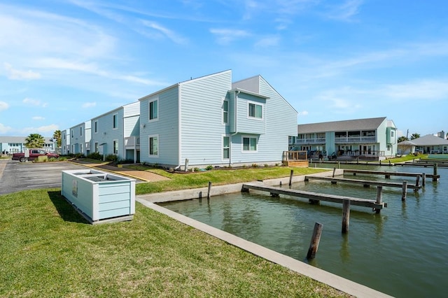 rear view of property with a water view and a lawn