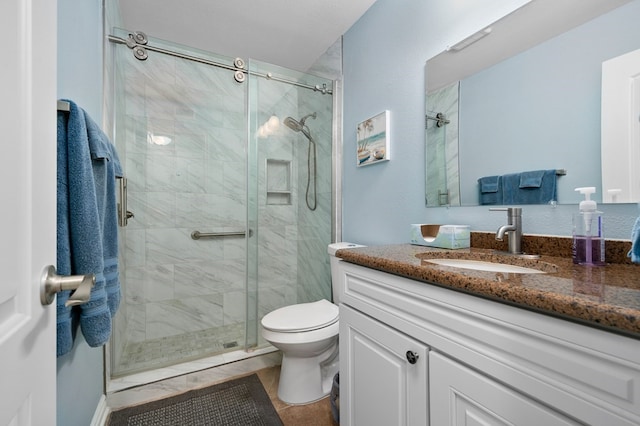 bathroom featuring tile patterned flooring, an enclosed shower, vanity, and toilet