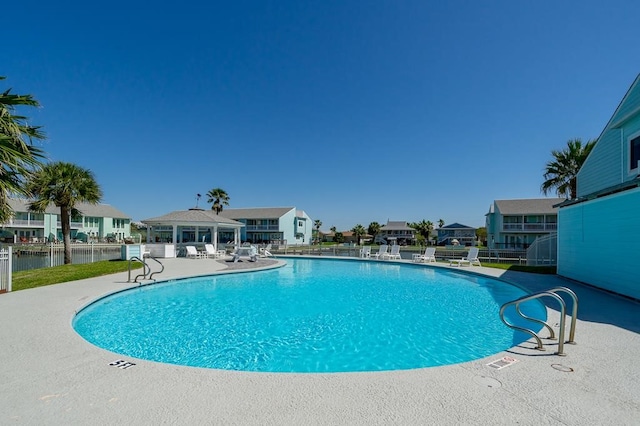 view of pool featuring a patio area and a water view