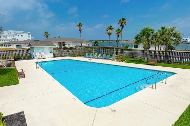 view of swimming pool featuring a water view and a patio area