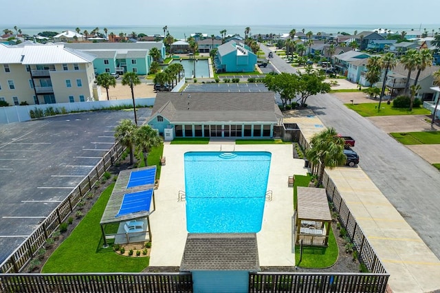 view of pool with a patio area, a water view, and a lawn