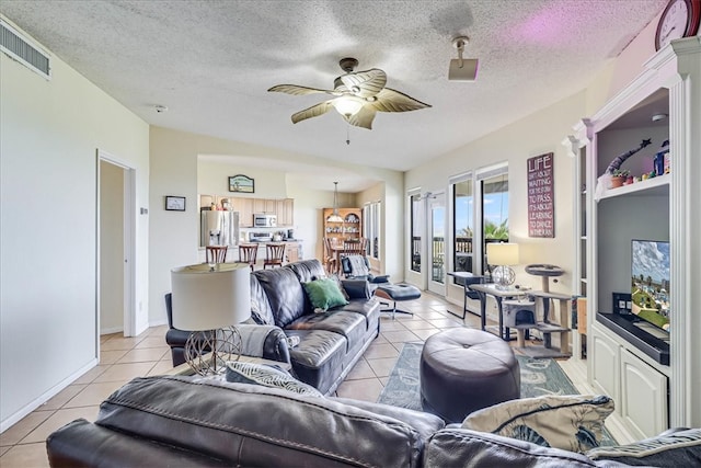 tiled living room with a textured ceiling and ceiling fan