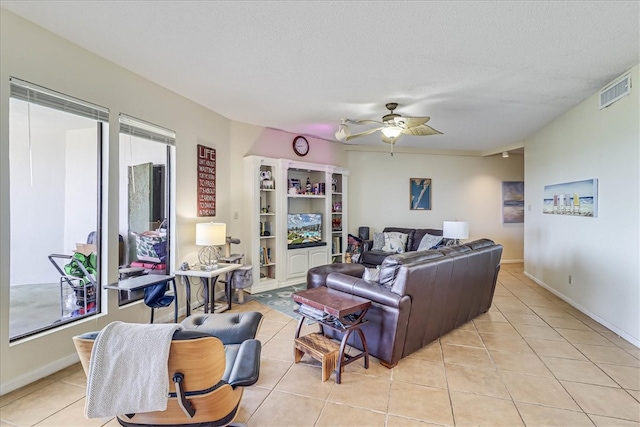 tiled living room with a textured ceiling and ceiling fan