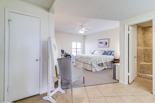 bedroom with ceiling fan, a textured ceiling, light tile patterned floors, and connected bathroom