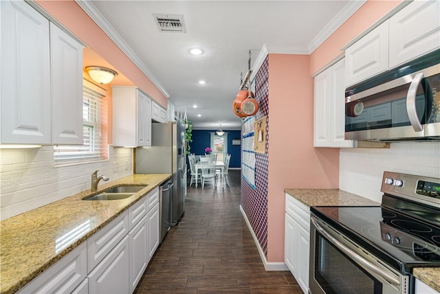101 Llano Dr, Portland, TX 78374 - kitchen featuring appliances with stainless steel finishes, white cabinets, crown molding, recessed lighting, and decorative backsplash