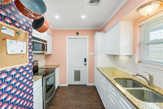 101 Llano Dr, Portland, TX 78374 - kitchen featuring appliances with stainless steel finishes, a sink, white cabinetry, ornamental molding, and dark wood finished floors