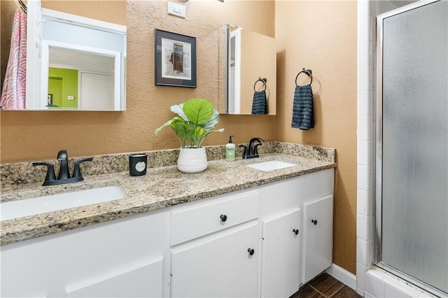 101 Llano Dr, Portland, TX 78374 - bathroom featuring a shower stall, double vanity, and a textured wall