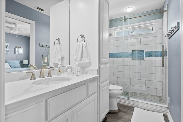 1819 Bay Shore Dr, Rockport, TX 78382 - ensuite bathroom with a shower stall, toilet, vanity, and a ceiling fan