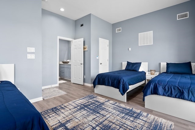 1819 Bay Shore Dr, Rockport, TX 78382 - bedroom featuring wood finished floors, baseboards, a towering ceiling, recessed lighting, and ensuite bath