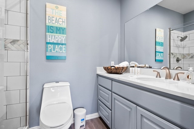 1819 Bay Shore Dr, Rockport, TX 78382 - bathroom with vanity, toilet, a tile shower, wood finished floors, and baseboards