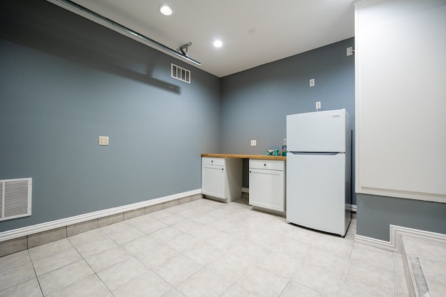 1819 Bay Shore Dr, Rockport, TX 78382 - kitchen featuring freestanding refrigerator, wooden counters, white cabinets, light tile patterned floors, and recessed lighting