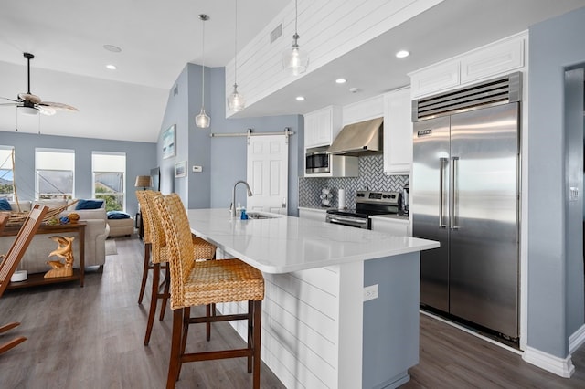 1819 Bay Shore Dr, Rockport, TX 78382 - kitchen with built in appliances, a sink, ventilation hood, ceiling fan, and dark wood-type flooring