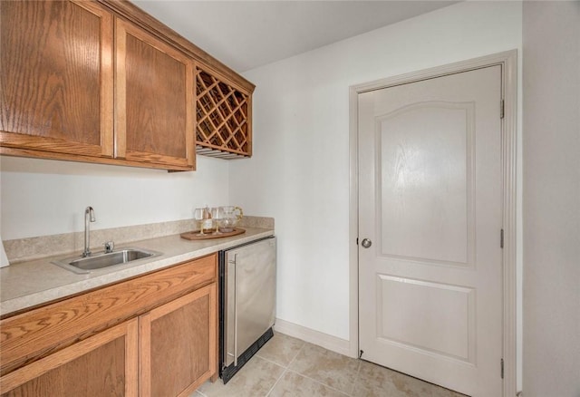 46 E Bar Le Doc Dr, Corpus Christi, TX 78414 - kitchen featuring a sink, light countertops, light tile patterned flooring, brown cabinets, and baseboards