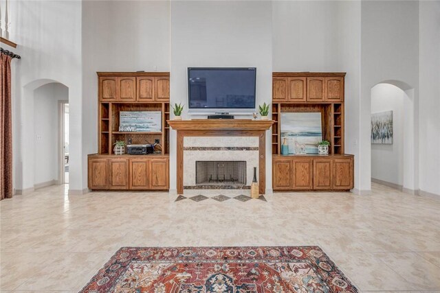 46 E Bar Le Doc Dr, Corpus Christi, TX 78414 - living area featuring arched walkways, a high ceiling, a fireplace, and baseboards