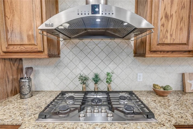 46 E Bar Le Doc Dr, Corpus Christi, TX 78414 - kitchen featuring exhaust hood, stainless steel gas cooktop, brown cabinetry, and decorative backsplash