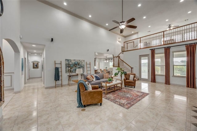 46 E Bar Le Doc Dr, Corpus Christi, TX 78414 - living room with a towering ceiling, a ceiling fan, arched walkways, ornamental molding, and stairway