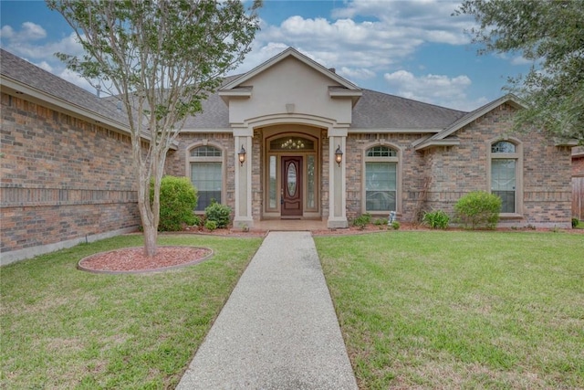 46 E Bar Le Doc Dr, Corpus Christi, TX 78414 - view of front of home with a front yard, a shingled roof, and brick siding